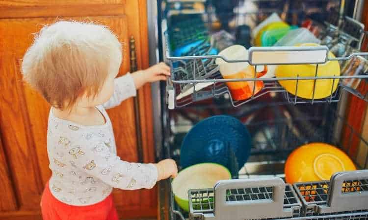 young toddler helping with clean dishwasher