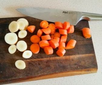chopped carrots and parsnip on wooden cutting board for baby food