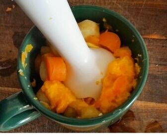 puree carrots and parsnips for baby food in green mug