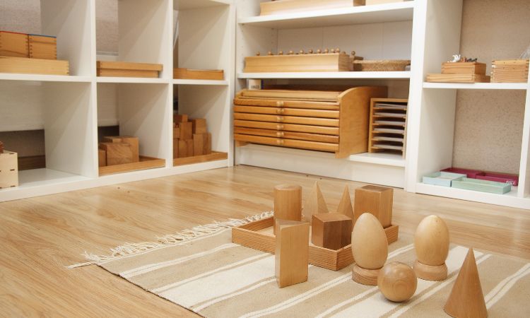 Montessori shelf in a montessori classroom with assorted wooden materials. 