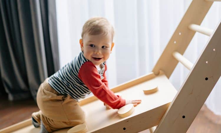 small toddler boy climbing montessori pikler slide